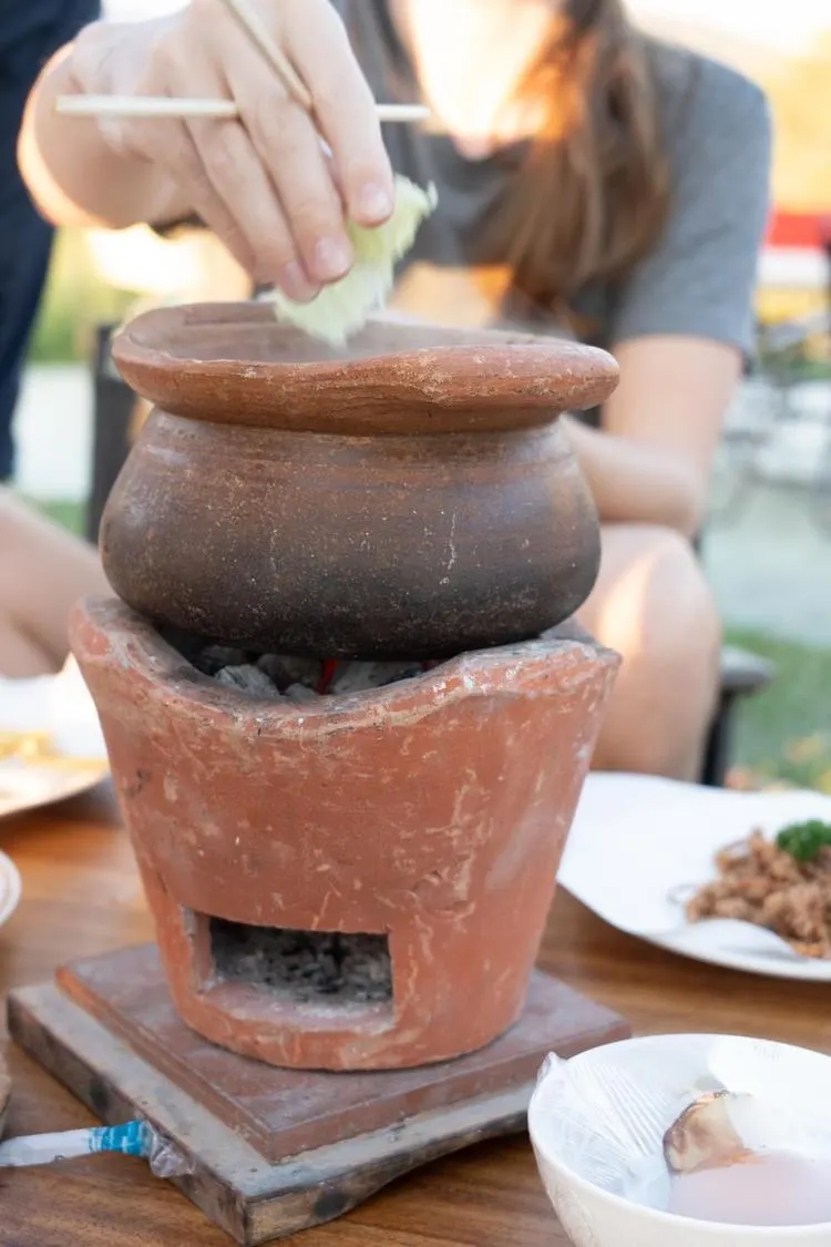 A traditional clay mortar and cooking utensils