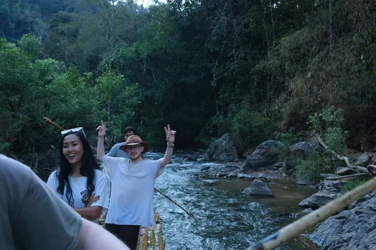 Two participants standing by a jungle river