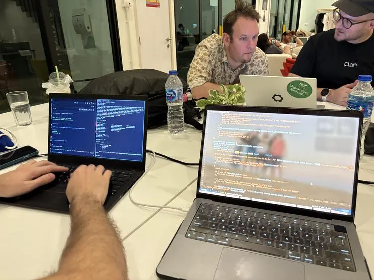 Laptops open on a table while participants hack on Nix