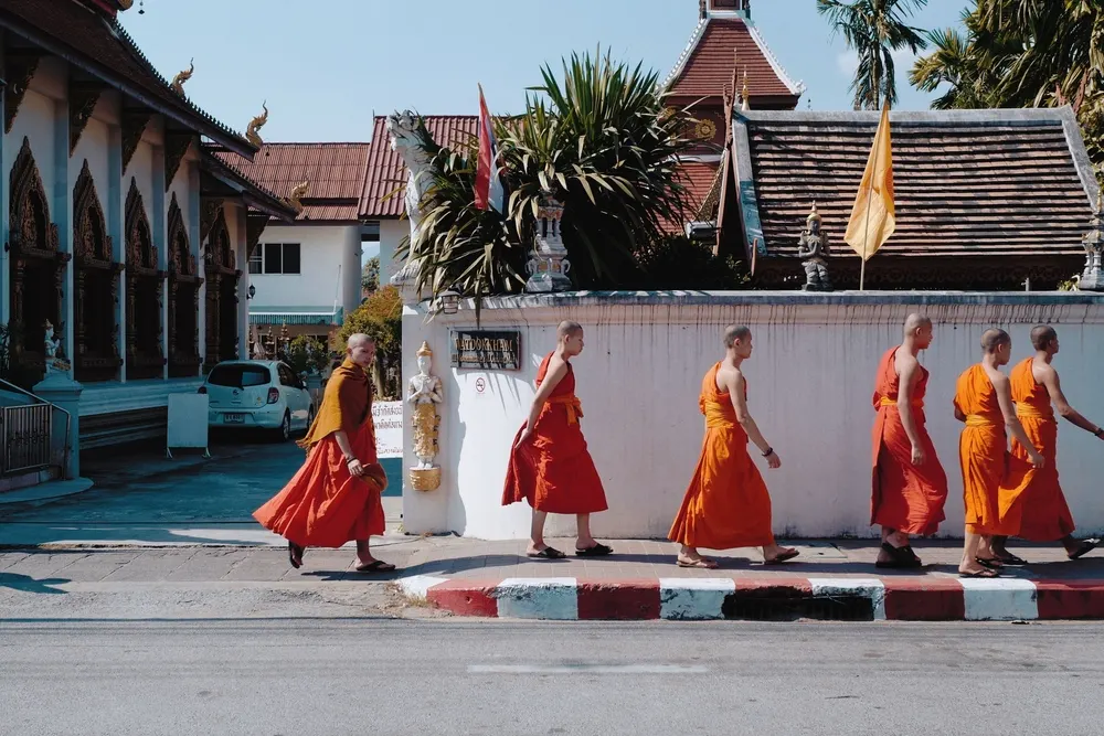 Buddhist monks in saffron robes walking along a street